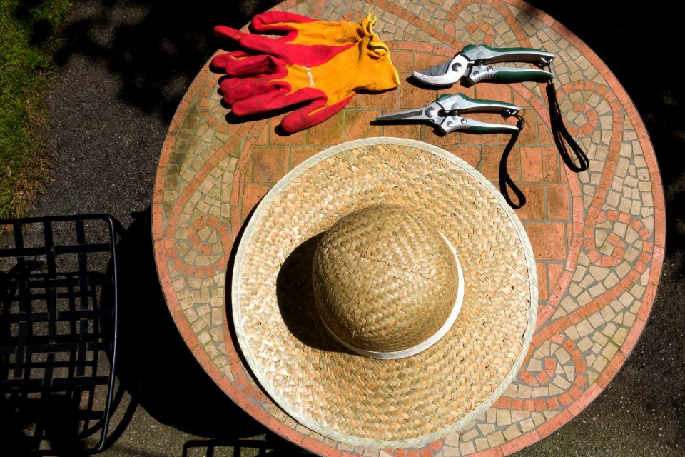 Brown Woven Hat Over Brown Wooden Round Table Top