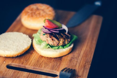 Shallow Focus Photography Of Burger Sandwich Served On Brown Wooden Chopping Board photo
