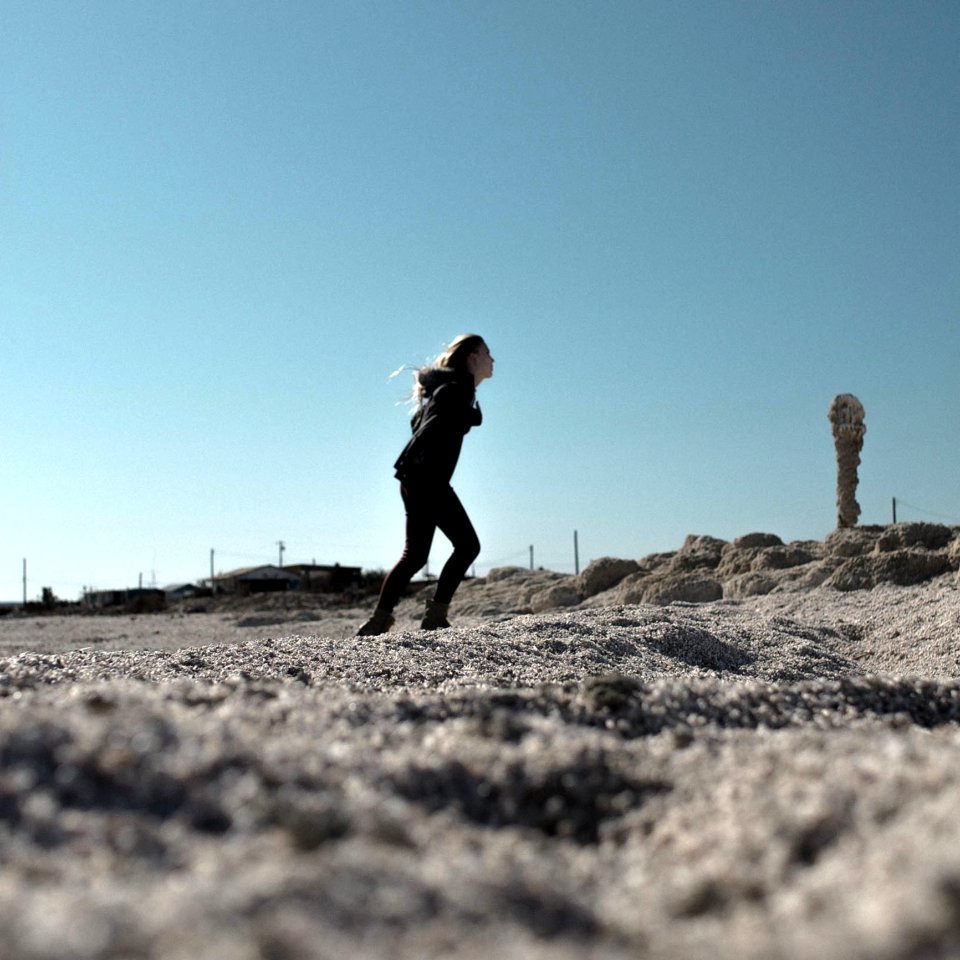 Woman In Black Hoodie And Skinny Jeans In Sandy Field