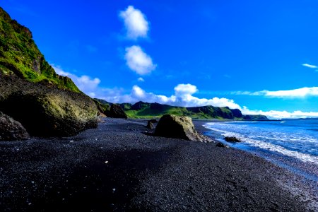 Rocky Beach Against Green Cliffs photo