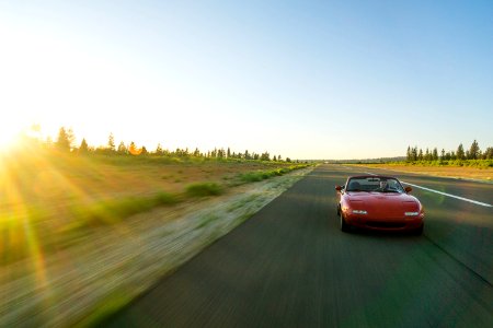 Red Sports Car Running On The Road Under Blue Sky During Daytime photo