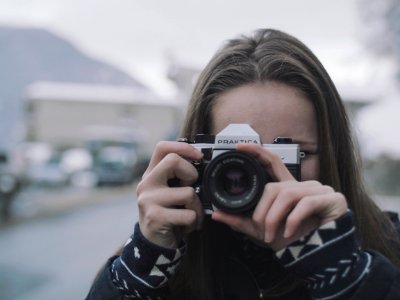 Woman Wearing White And Black Coat Holding Black And Gray Digital Camera