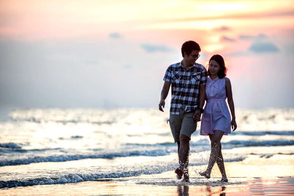 Couple Strolling On Beach At Sunset photo