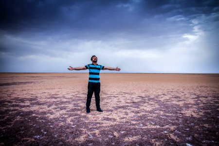 Man Standing In Desert With Open Arms