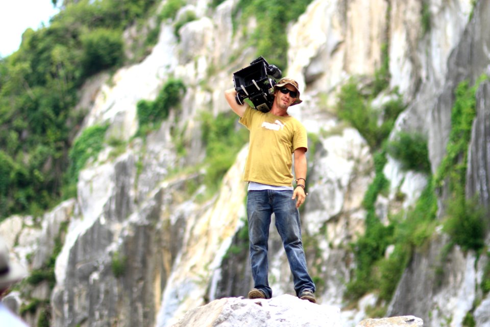 Cameraman Standing On Rocky Ledge