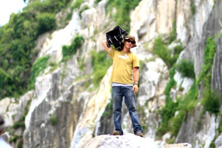 Cameraman Standing On Rocky Ledge