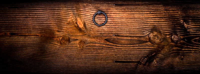 Gray Metal Door Knocker On Wooden Panel