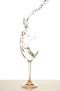Wine Splashing In Stemmed Glass