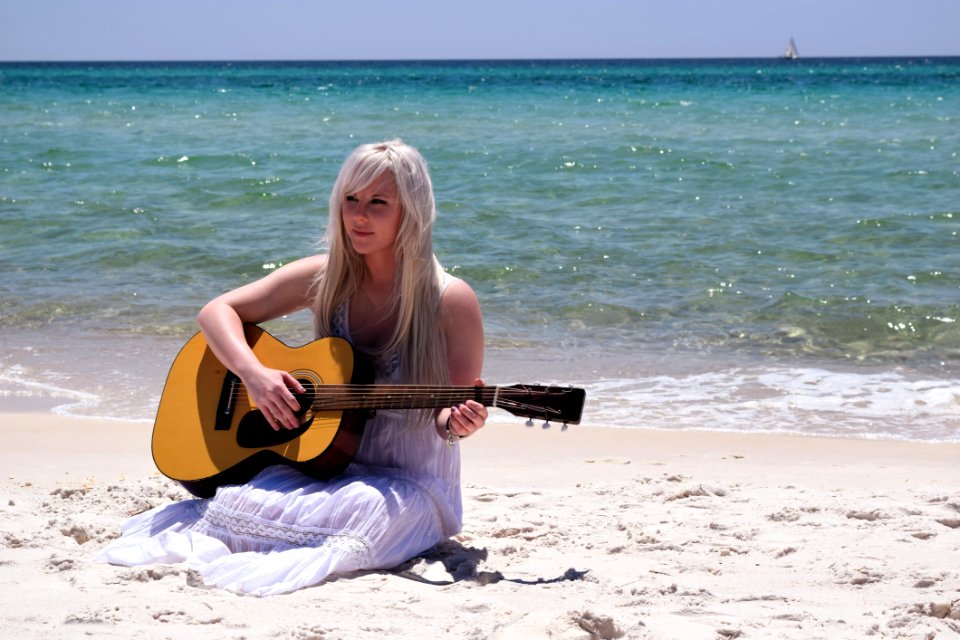 Blond Woman Playing Spruce Top Dreadnought Acoustic Guitar By The Seashore