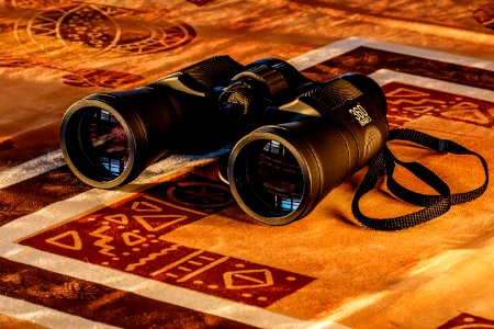 Black Binoculars In Maroon And Beige Textile photo