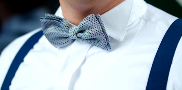 Man In White Dress Shirt Blue Suspenders And Gray Polka Dotted Bowtie photo