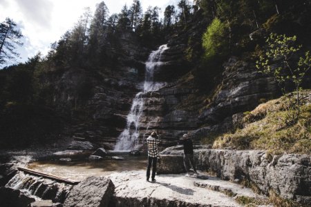Hikers By Waterfall In Forest photo