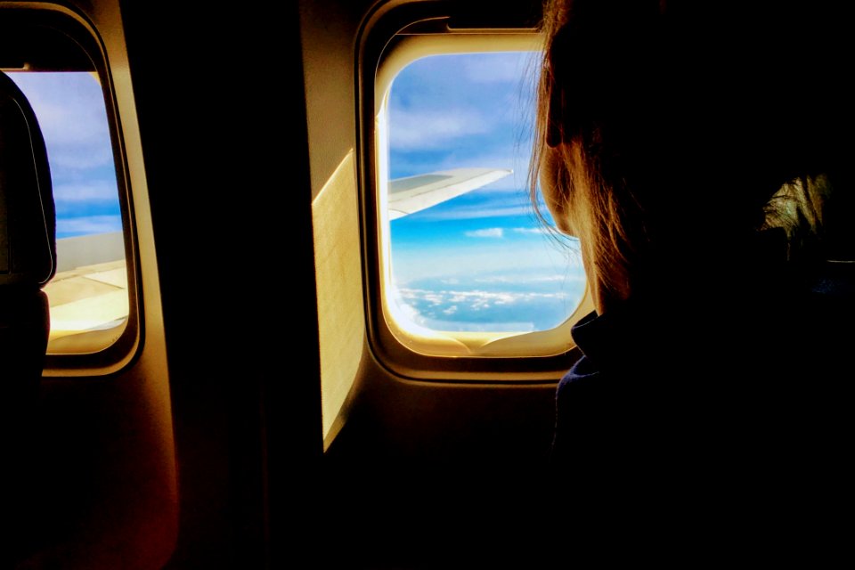 Woman Looking Through Airplane Window