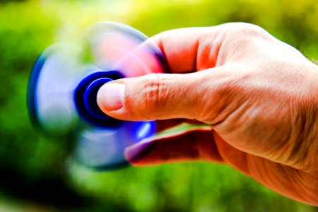 Hand Of Man Using Fidget Spinner