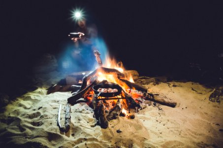 Man With Headlamp Next To Campfire photo