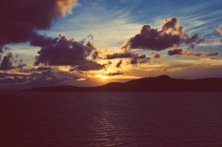 Faded Sunset Over Ocean With Land