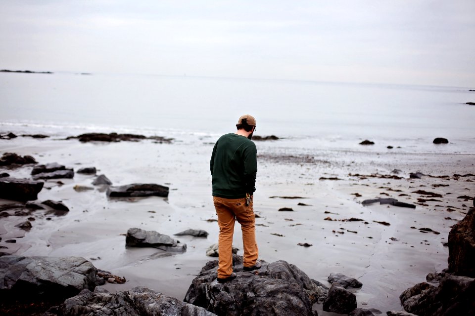 Man Standing On Rocks At Seaside