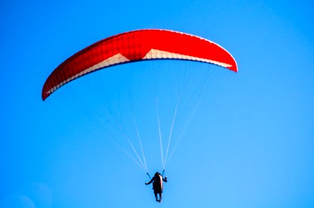 Person Using Red Parachute On Mid Air photo