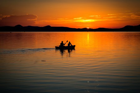 2 Person On Boat Sailing In Clear Water During Sunset photo