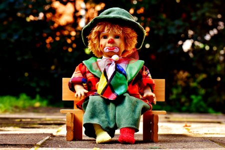 Clown Doll On Bench Outdoors photo