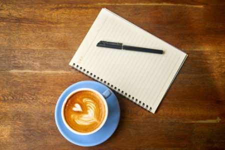 Coffee Next To Notepad And Pen photo