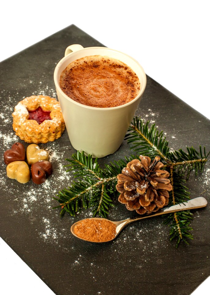 White Ceramic Mug With Brown Liquid And Pine Cone photo