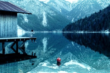 Man On Boathouse On Mountain Lake photo