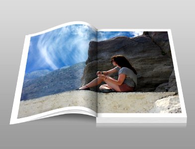 Woman In Gray Shirt Sitting Over Brown Formation Of Rock During Daytime Book photo