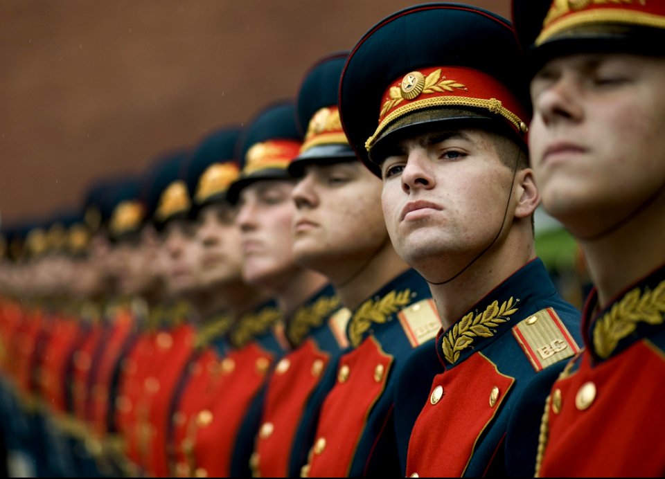 Men In Black And Red Cade Hats And Military Uniform