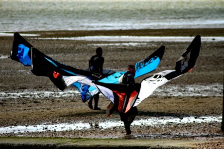 Men Carrying Black Red And White Kite