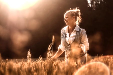 Mid Adult Woman In Wheat At Sunset