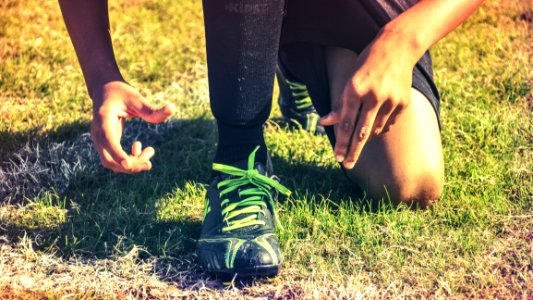 Man Wearing Athletic Shoes In Grassy Field