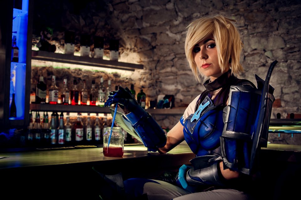 Woman In Blue And Black Mascot Sitting Near Drinking Glass