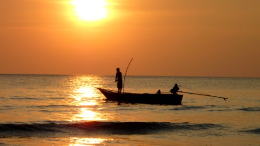 Fisherman In Boat At Sunset photo
