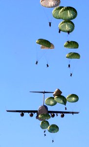 Army Paratroopers Practicing Parachute Drop From A Military Air Plane During Daytime photo