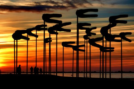 Silhouette Parasols Against Dramatic Sky During Sunset photo