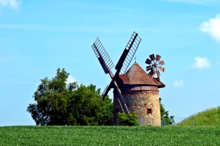Brown And Gray Windmill Beside Green Tree Under Blue Cloudy Sky During Day Time photo