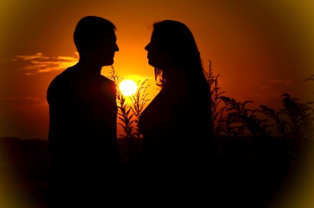 Silhouette Of Man And Woman During Sunset photo