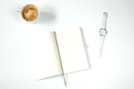 White Leather Strap Silver Round Analog Watch Next To Notebook