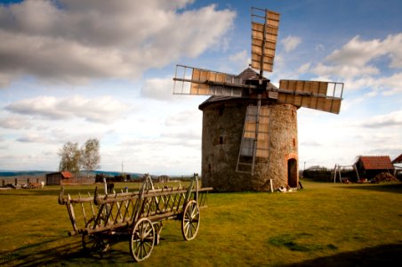 Wooden Windmill Near Wooden Carriage During Daytime photo