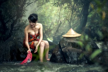 Asian Woman Washing Clothes In Stream photo