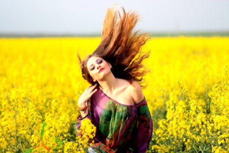 Portrait Of Young Woman With Yellow Flowers In Field photo