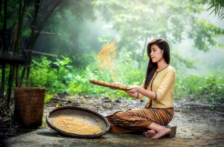 Asian Woman Sifting Grain photo