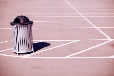 Grey Black Trash Can Empty Parking Lot White Lines Shadow photo