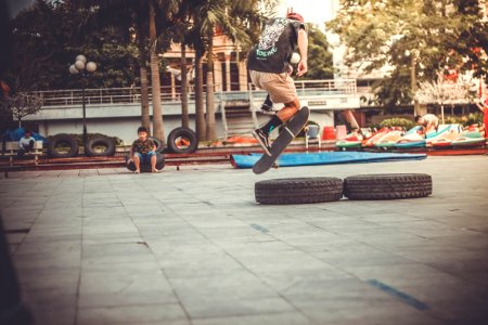 Skateboarder Jumping Over Tires