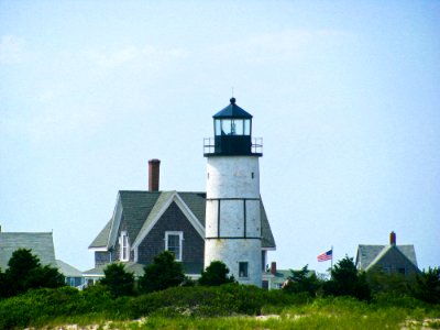 Lighthouse By Home With American Flag photo