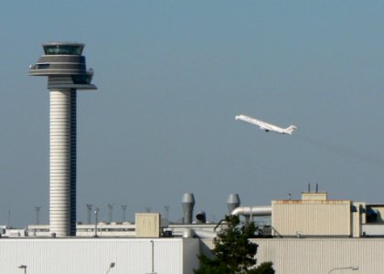 Airfield Control Tower With Airplane In Background