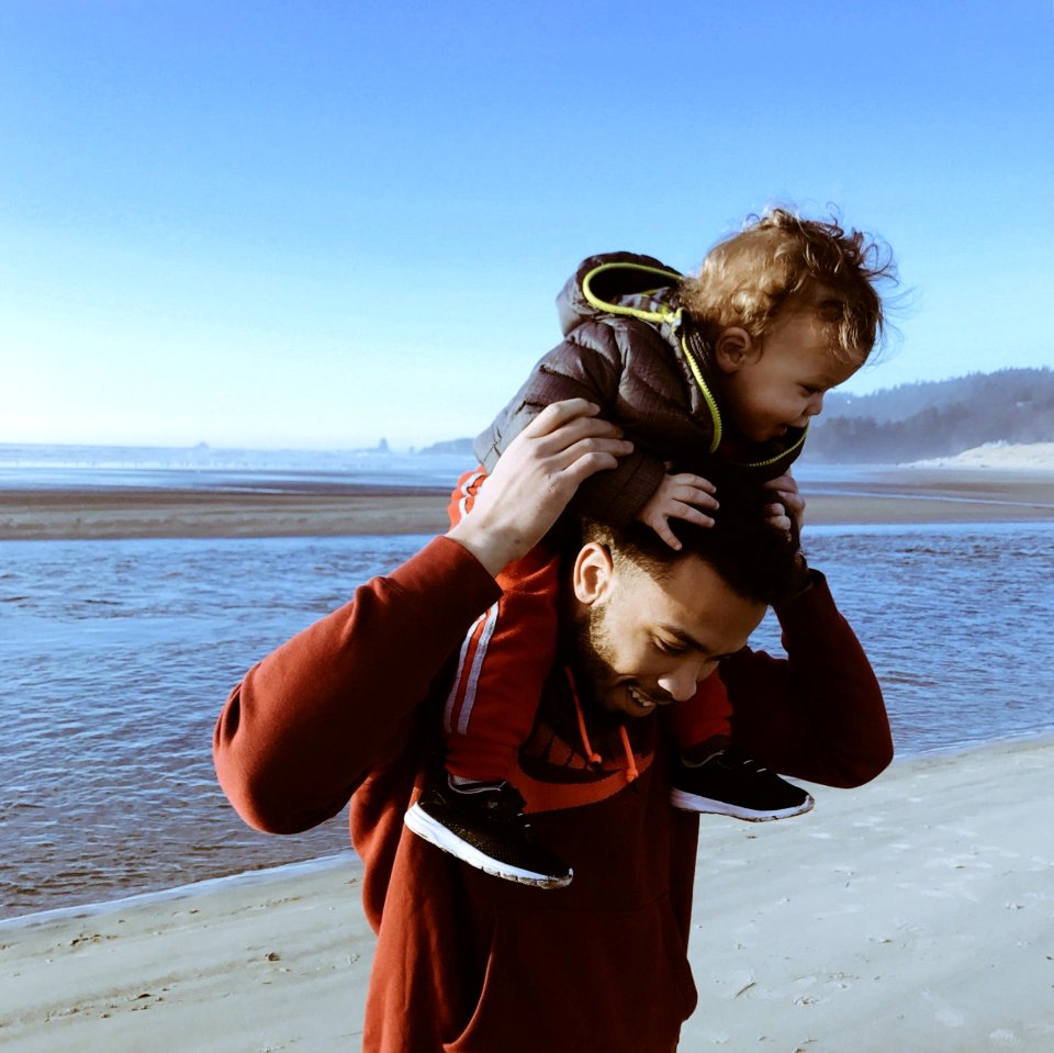 Father On Beach Carrying His Son