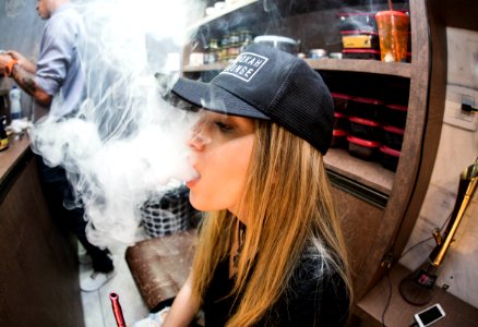 Young Woman Vaping In Restaurant photo