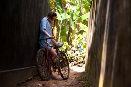 Girl With Bicycle On Narrow Alley photo